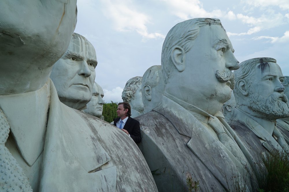 Alex Keena among the presidential head sculptures at Presidents Park, Virginia